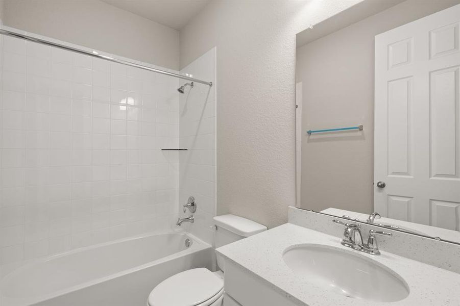 The secondary bath features tile flooring, white cabinetry and light countertops and a shower/tub combo. Perfect for accommodating any visiting family and friends.