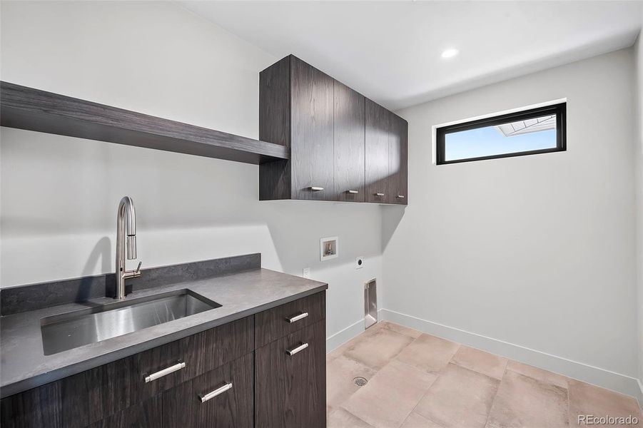 Laundry room with ample cabinetrs and shelf.