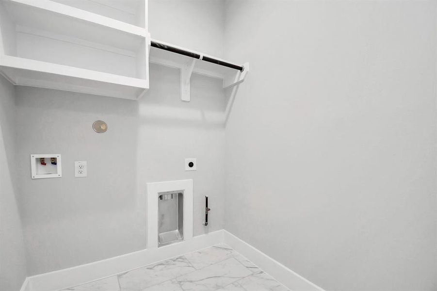 Located on first floor, a stylish laundry room where practicality meets a contemporary aesthetic. The dark finishes lend a sophisticated touch, creating a space that is both functional and visually appealing. Both electric and gas connections available.