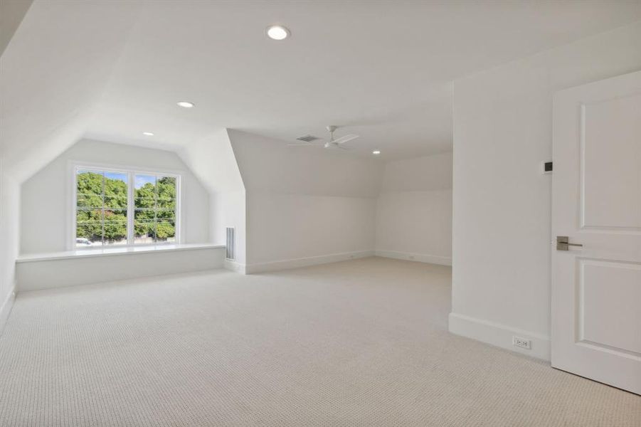 Bedroom featuring ceiling fan, light colored carpet, and lofted ceiling