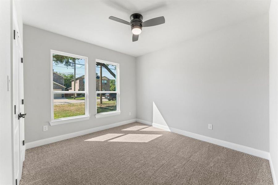 Spare room with ceiling fan and light colored carpet