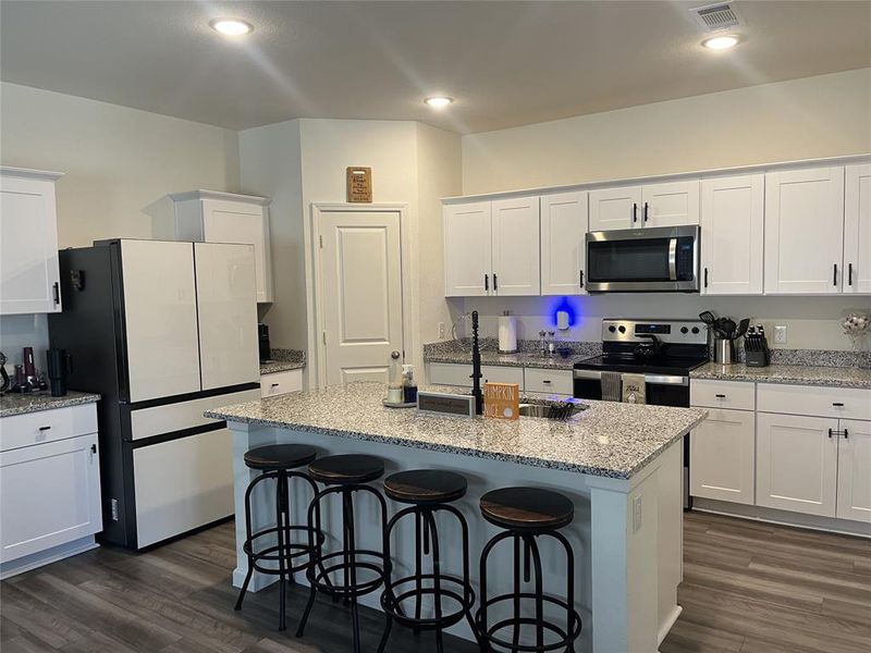 Kitchen featuring white cabinetry, stainless steel appliances, and dark hardwood / wood-style flooring