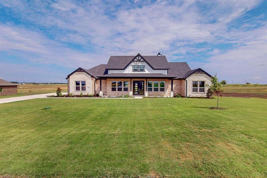 View of front of property featuring a front yard and a rural view