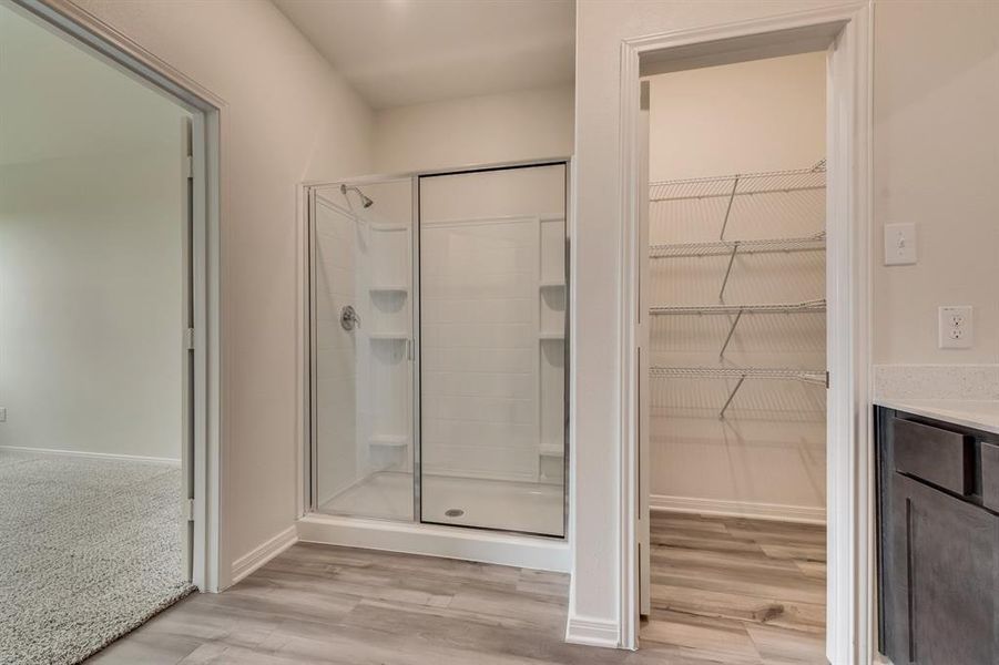 Bathroom with a shower with shower door, vanity, and hardwood / wood-style floors