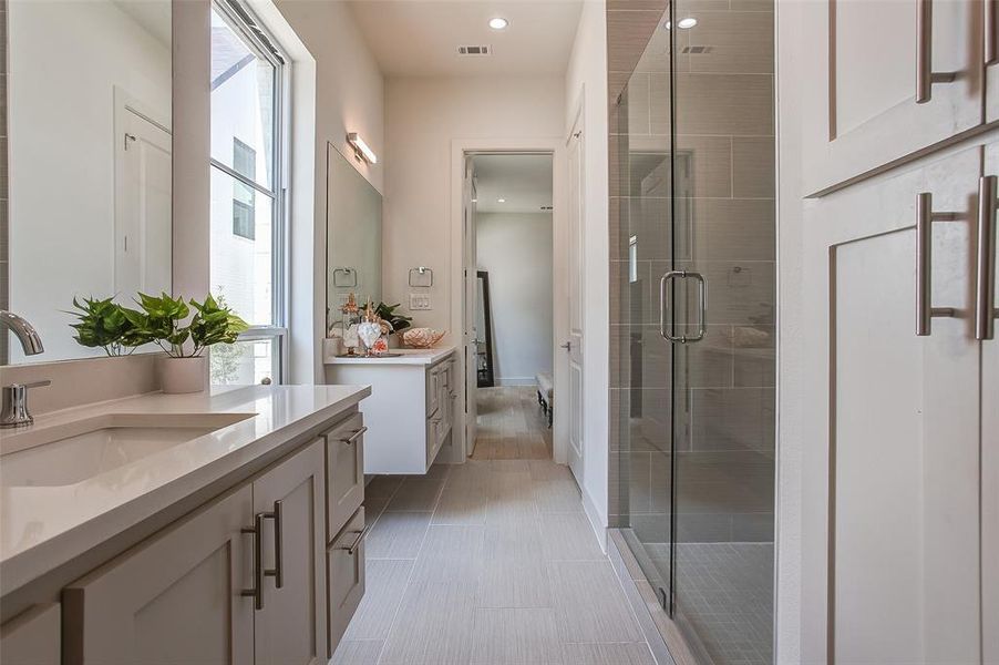Bathroom featuring walk in shower, vanity, and tile floors