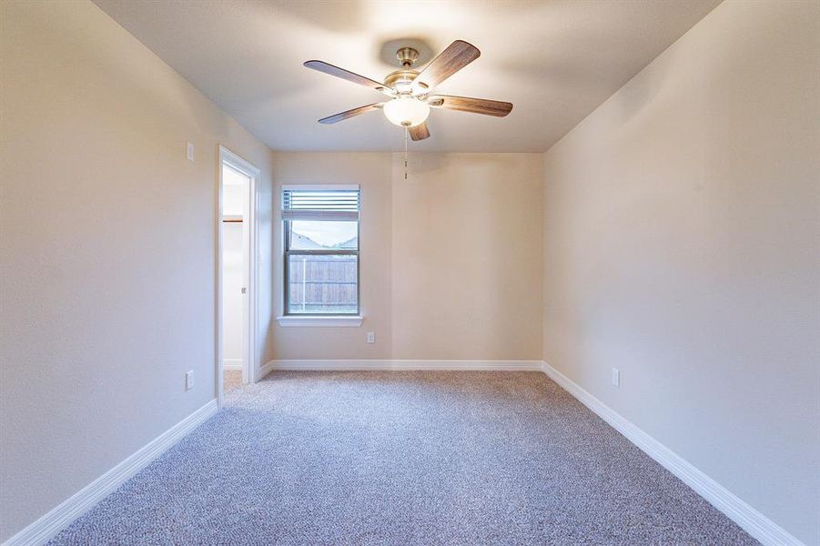 Carpeted spare room featuring ceiling fan