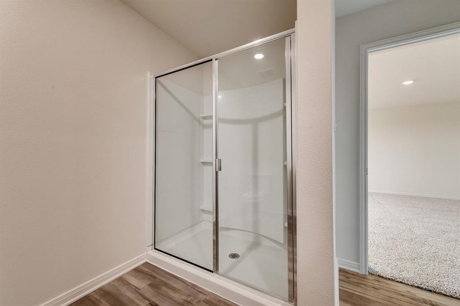 Bathroom with a shower with door and hardwood / wood-style flooring