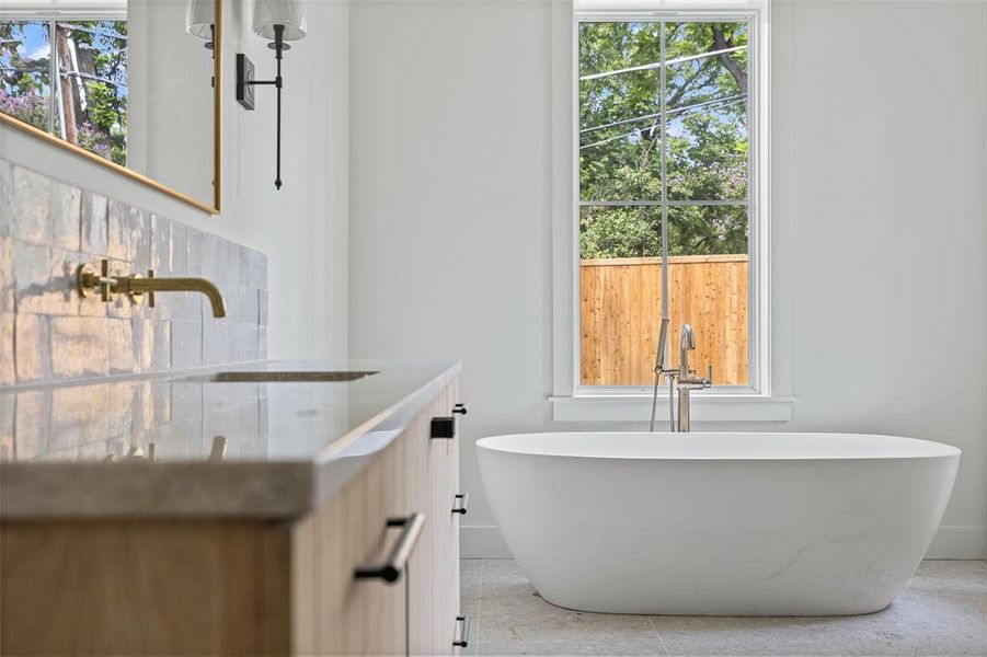 Bathroom with a tub to relax in, vanity, and tile patterned floors