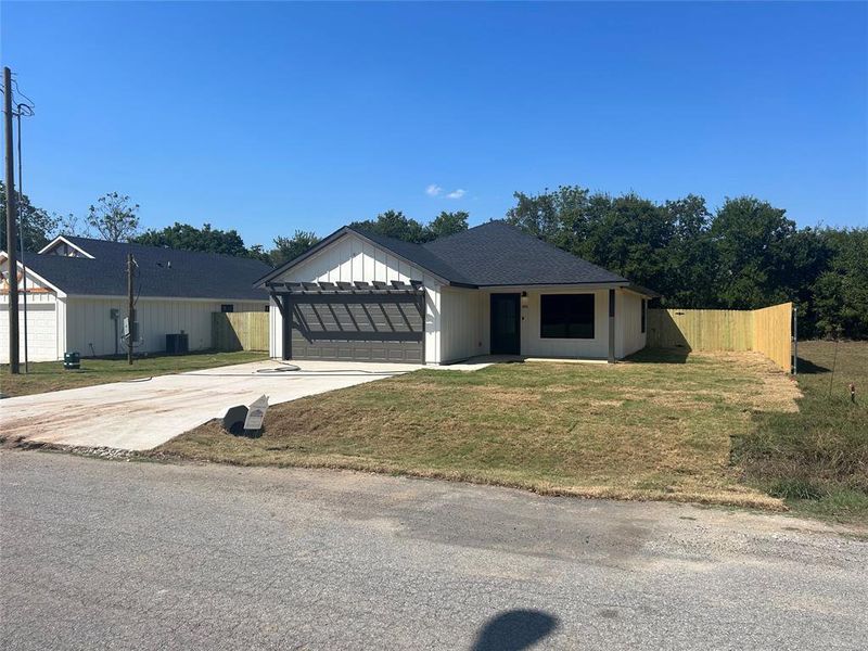 View of front of home with a front yard and a garage