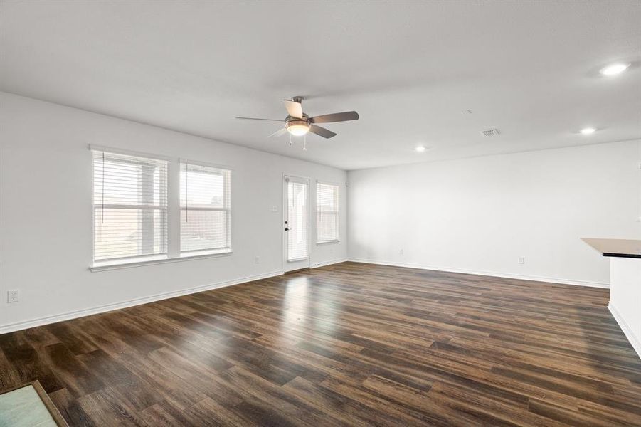 Unfurnished living room with ceiling fan and dark wood-type flooring