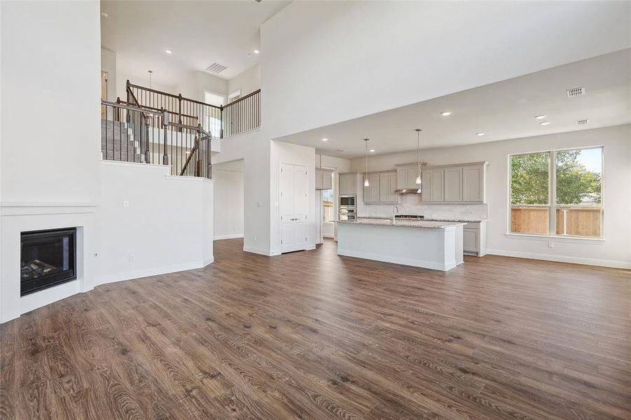 Unfurnished living room featuring dark hardwood / wood-style flooring and a high ceiling