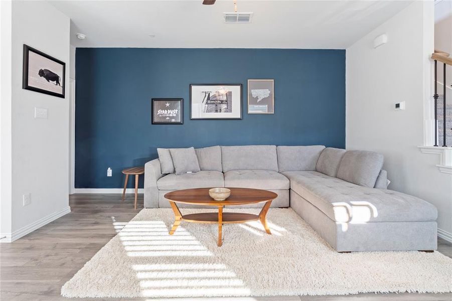 Living room featuring ceiling fan and laminate wood flooring.