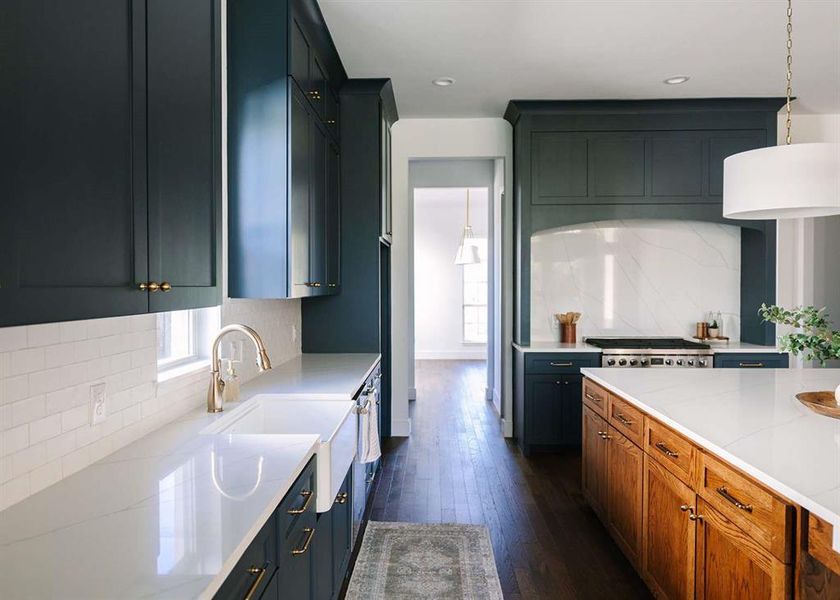 Kitchen featuring hanging light fixtures, backsplash, dark hardwood / wood-style floors, and light stone counters