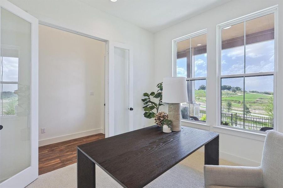 Office space with dark hardwood / wood-style floors