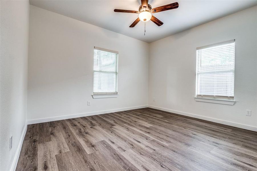 Unfurnished room featuring ceiling fan, hardwood / wood-style flooring, and plenty of natural light