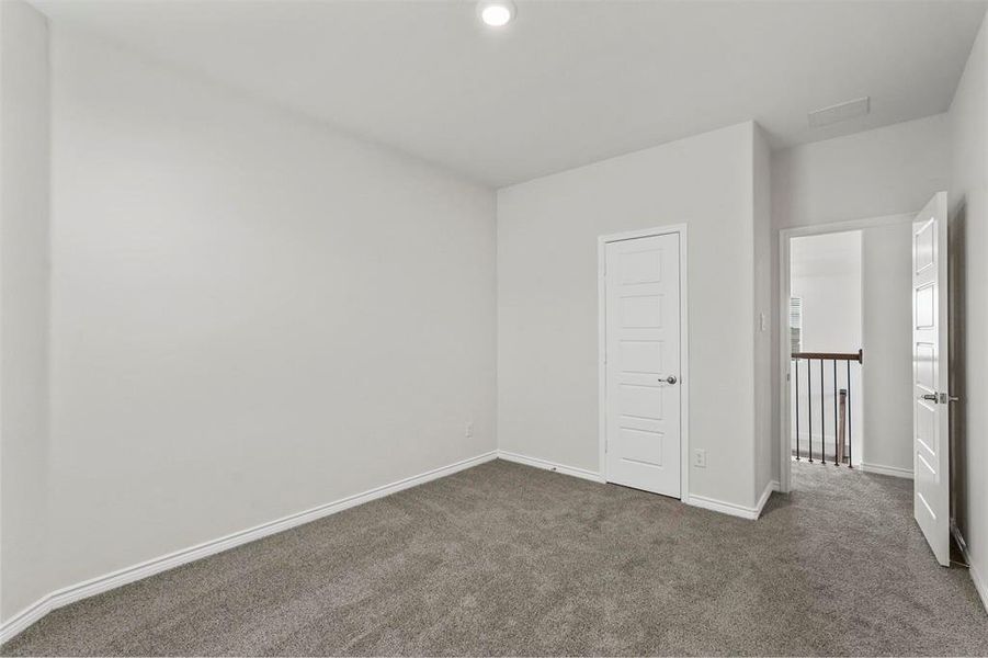 Unfurnished bedroom featuring a closet and dark carpet