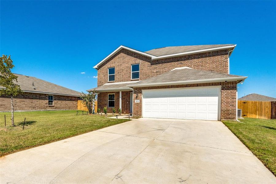 View of front property featuring a front lawn and a garage