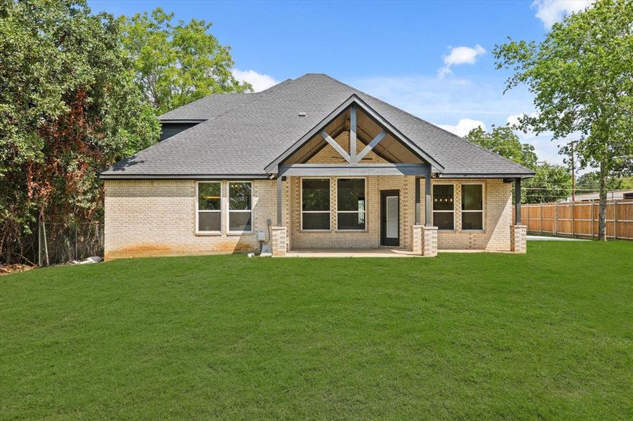 Rear view of house with a patio area and a yard