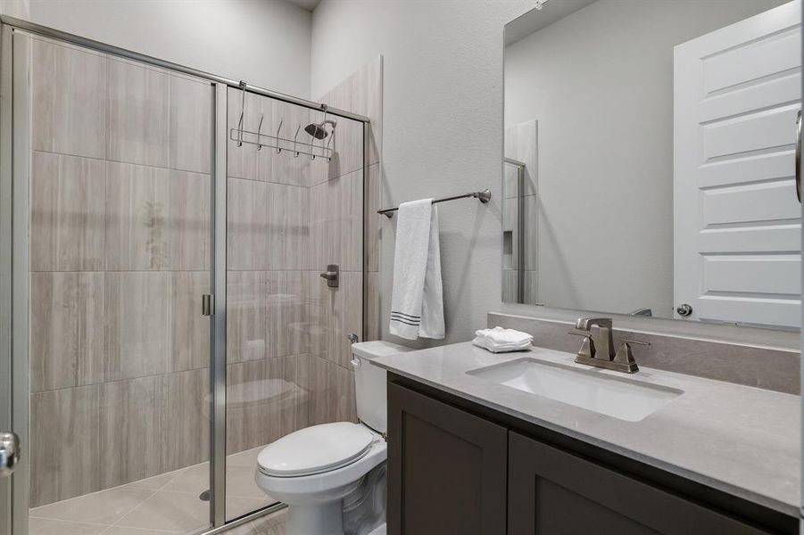 Bathroom with a shower with door, toilet, and vanity