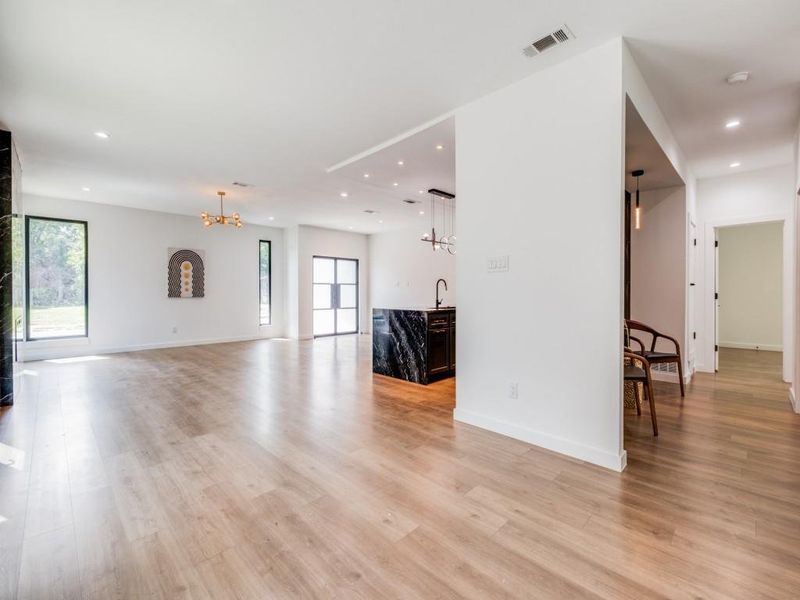 Living room featuring a notable chandelier, light wood-type flooring, and sink