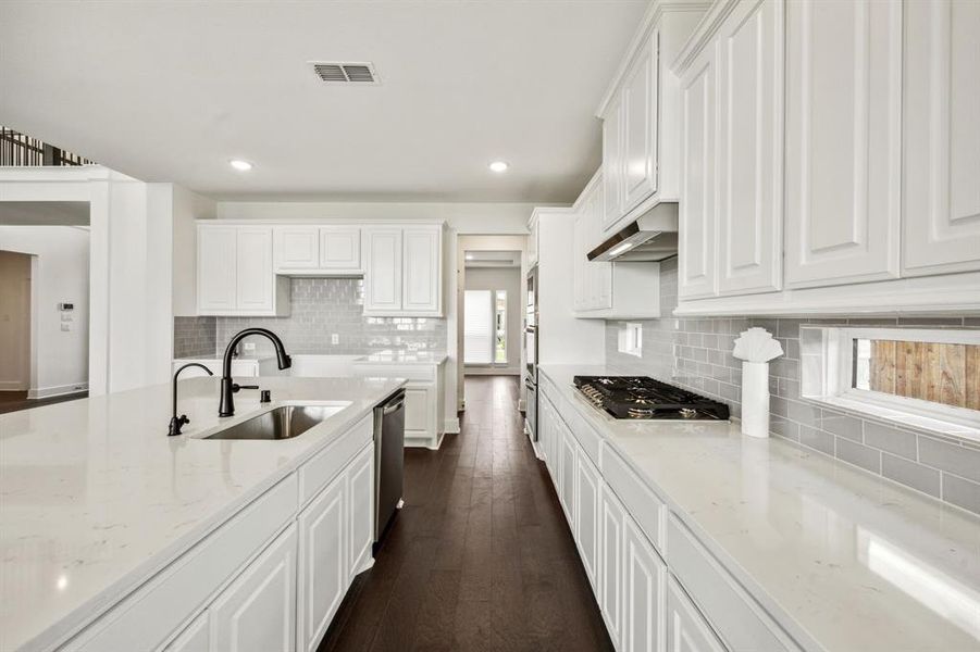 Kitchen with white cabinets, stainless steel appliances, sink, and a healthy amount of sunlight