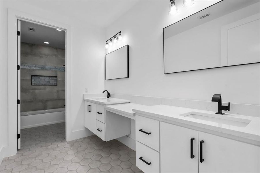 Bathroom with shower / bathtub combination, tile patterned floors, and double vanity