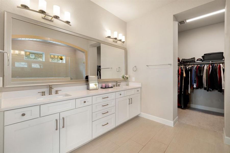 This primary bathroom is definitely move-in ready! Featuring a custom spa like walk-in tile shower with rain shower head, double sinks, framed mirror, white cabinets with Quartz countertops, spacious walk-in closet with shelving, high ceilings, neutral paint, sleek and modern finishes.