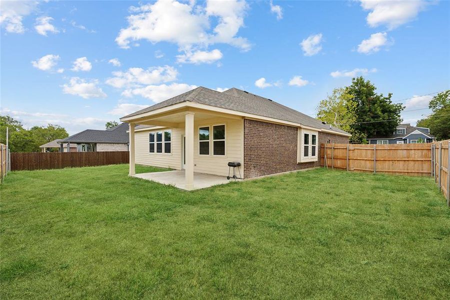 Rear view of house featuring a lawn and a patio