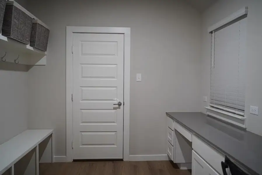 Mudroom featuring built in desk and dark wood-type flooring