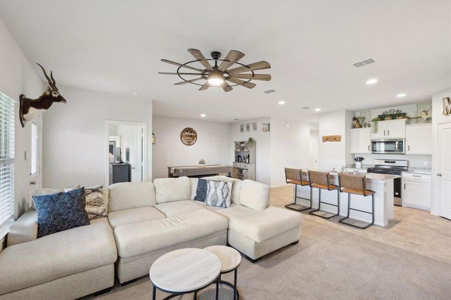 Carpeted living room featuring ceiling fan