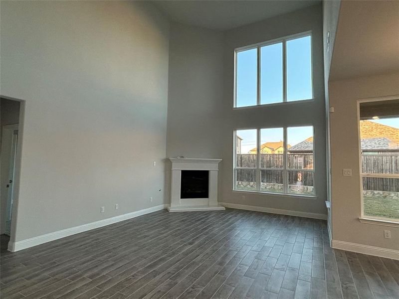 Unfurnished living room with a high ceiling and dark hardwood / wood-style floors