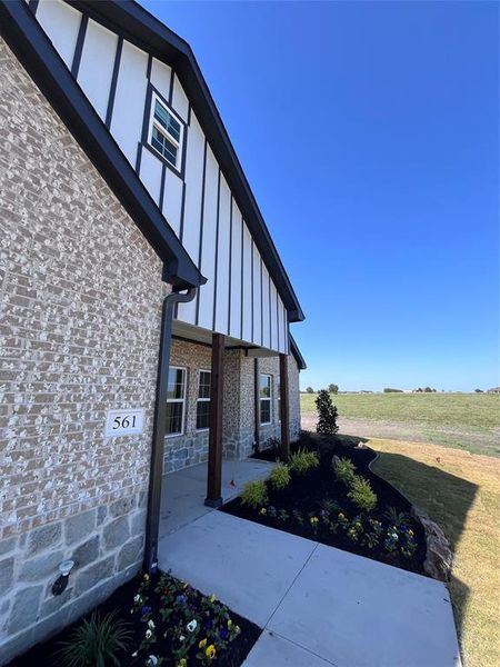 Doorway to property with a lawn and a patio area