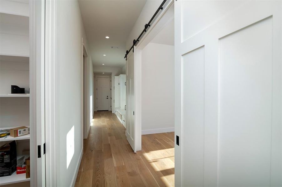 Hallway featuring a barn door and light wood-type flooring