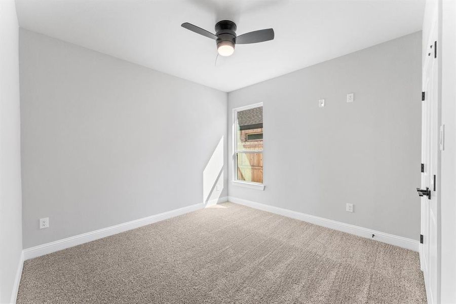 Carpeted spare room with ceiling fan