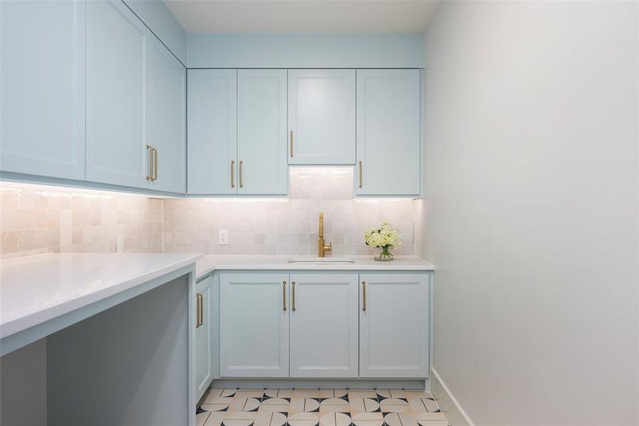 Kitchen featuring sink, light tile flooring, and backsplash