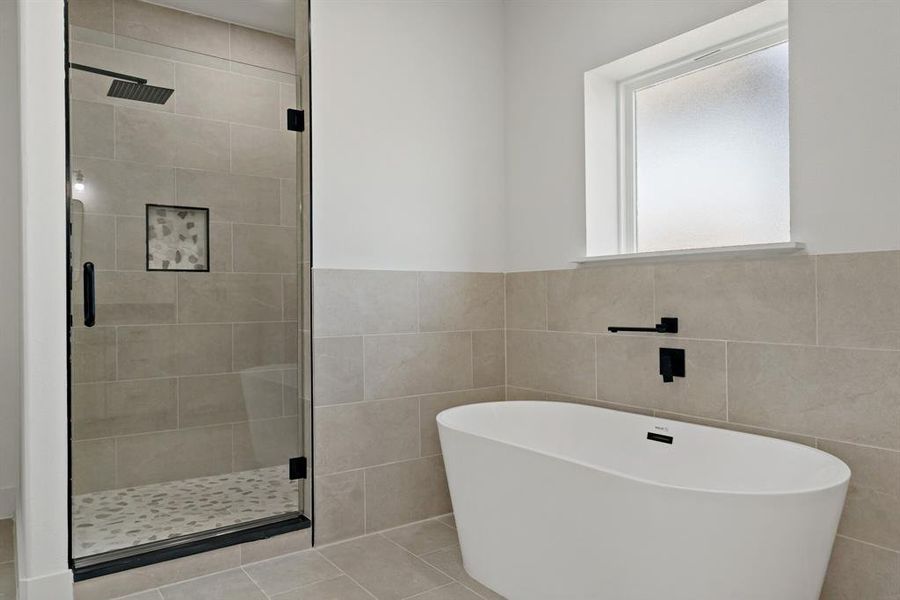 Bathroom with independent shower and bath, tile walls, and tile patterned floors