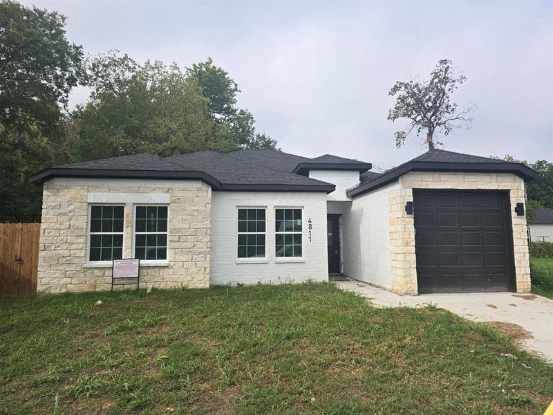 View of front of house featuring a garage and a front lawn