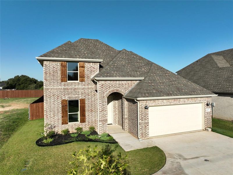 View of front of house with a front lawn and a garage