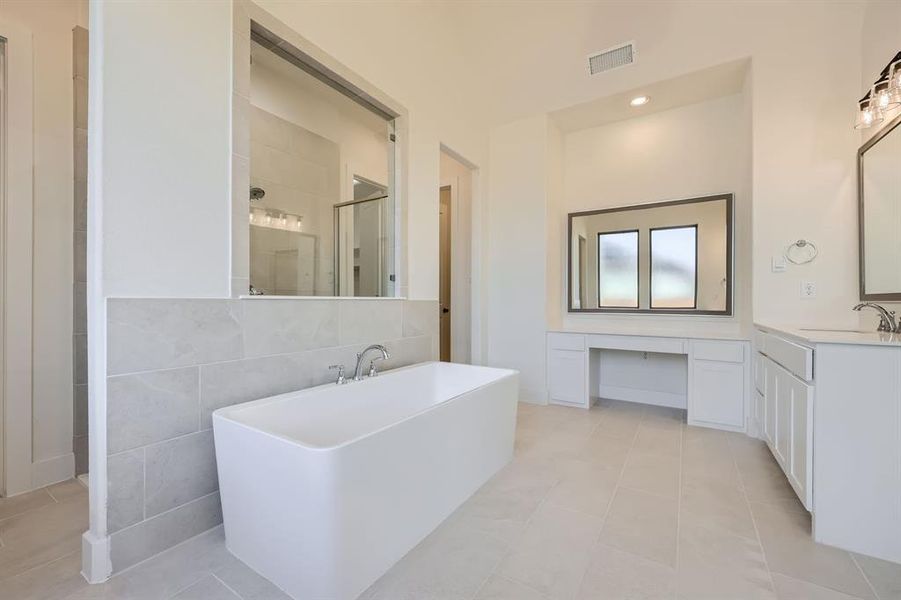 Bathroom featuring tile walls, vanity, plus walk in shower, and tile patterned flooring