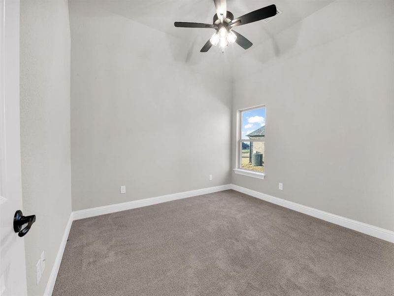 Spare room with ceiling fan, carpet floors, and lofted ceiling