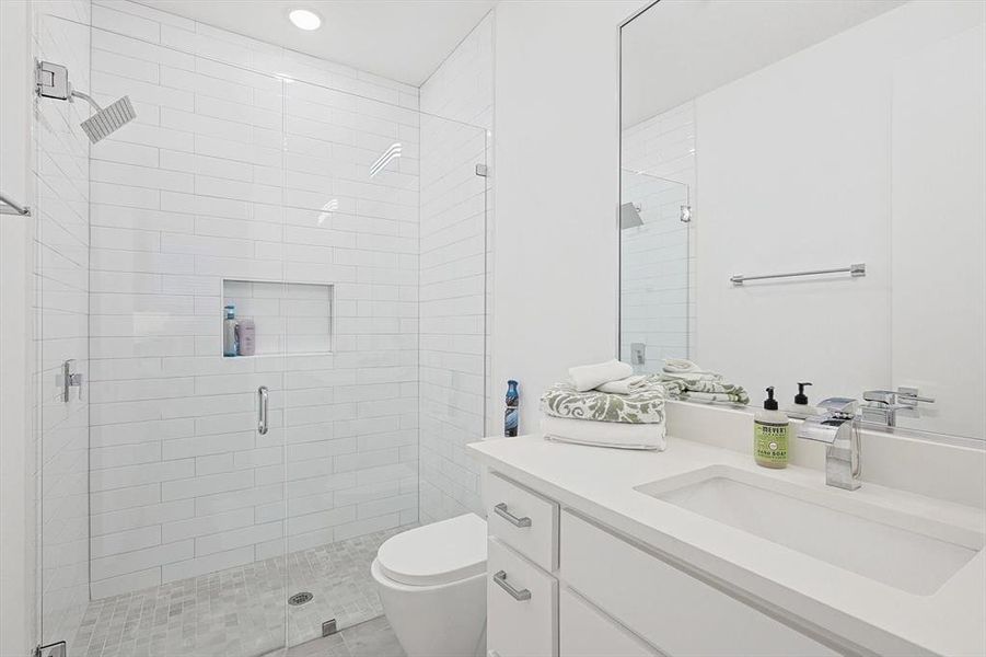 Bathroom featuring vanity, toilet, tile patterned floors, and a shower with door