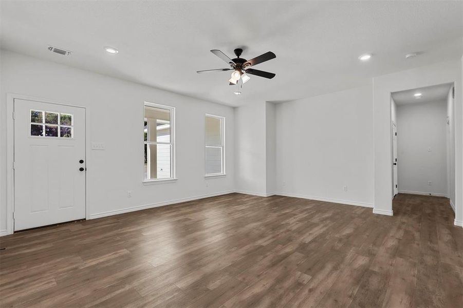 Unfurnished living room with dark hardwood / wood-style floors and ceiling fan