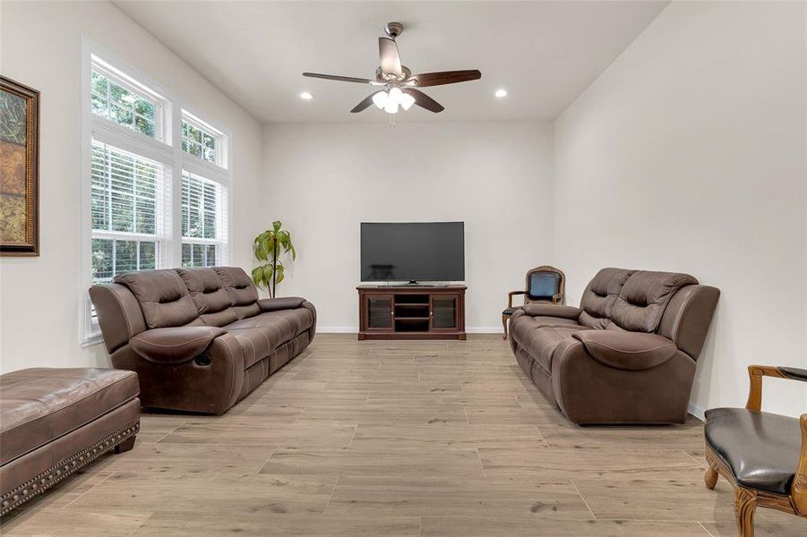 Spacious living room with high ceilings, large windows, and plenty of natural lighting.