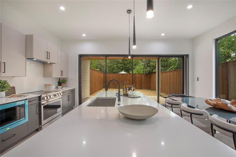 Kitchen with plenty of natural light, pendant lighting, stainless steel appliances, and sink