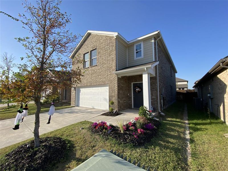 View of front of house featuring a garage and a front lawn