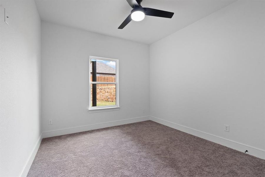 Carpeted spare room with ceiling fan