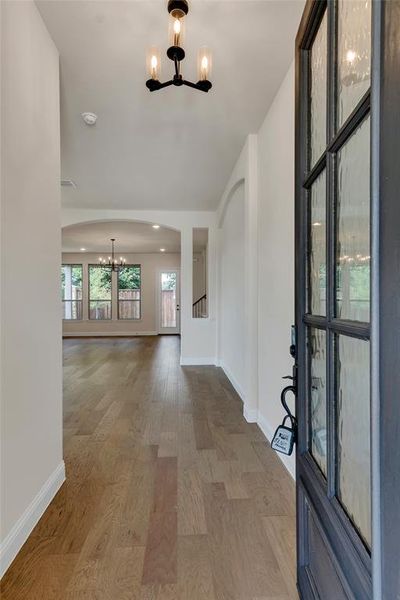 Foyer entrance with hardwood / wood-style flooring and a notable chandelier