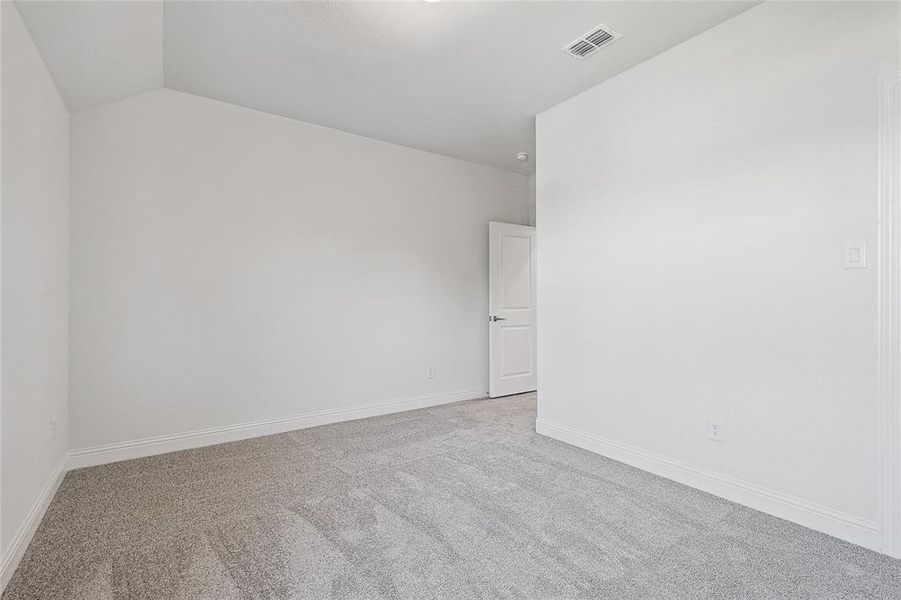 Carpeted spare room with lofted ceiling