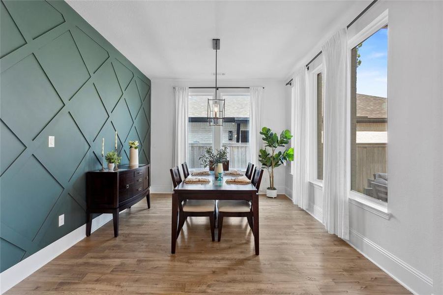 Custom wall installation and modern light fixture adorn the well-lit dining area