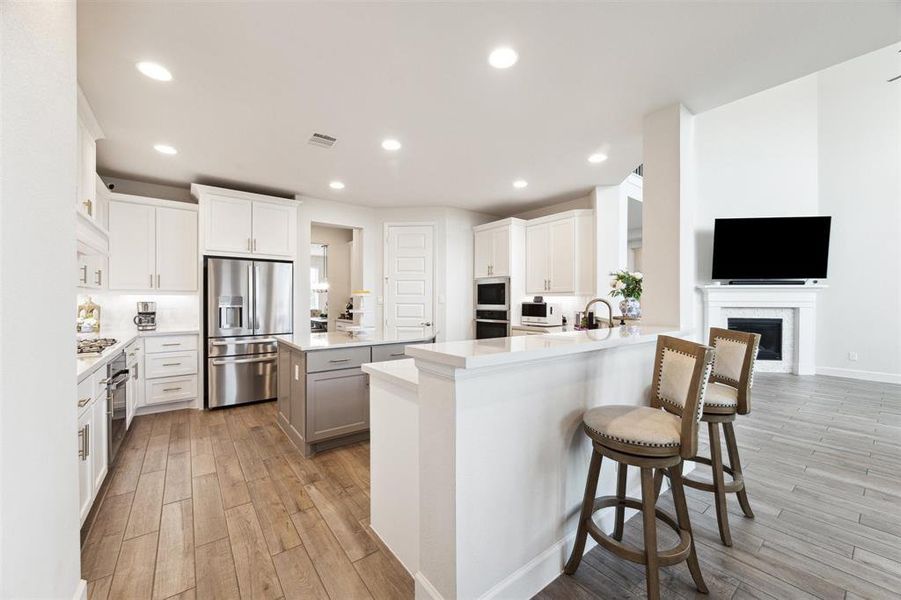 The kitchen as viewed when entering from the breakfast area. Features include ceramic tile floor, serving/ breakfast bar and recessed lighting.